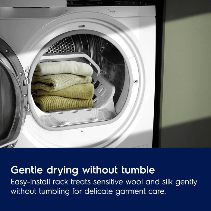 A stack of folded wool sweaters resting on a white internal drying rack inside an open Electrolux dryer drum.