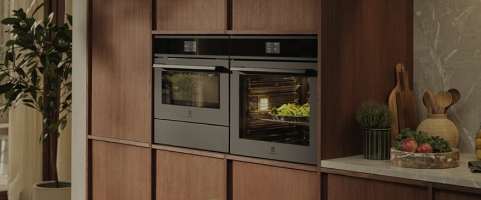Kitchen view with vegetables on table and Ovens in the back